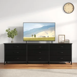 Flat-screen TV on a black console with a clock on the wall and a potted plant to the left in a modern living room.